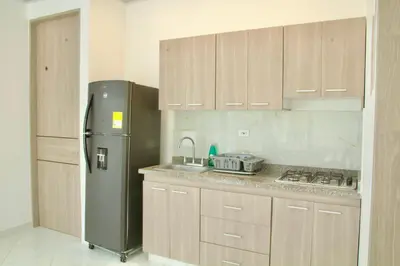 a kitchen with a stainless steel refrigerator and cabinets at Cabañas El Laguito Coveñas in Coveñas