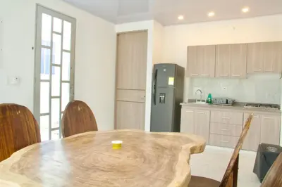 a kitchen with a wooden table and a refrigerator at Cabañas El Laguito Coveñas in Coveñas