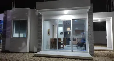 a house with glass doors with a person in it at Cabañas El Laguito Coveñas in Coveñas