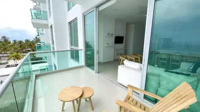 a balcony with a table and chairs on a building at Magico Apartamento Frente al Mar 4 Habitaciones BM43 in Coveñitas