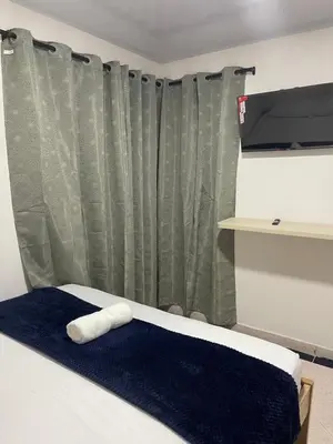 a bedroom with a bed with a blue blanket and a curtain at Hotel Casablanca in Galapa