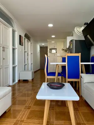 a living room with a table and blue chairs and a couch at apartamento con vista al Lago in Cartagena de Indias
