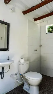 a white bathroom with a toilet and a sink at Cabañas en Cartagena JhonliMar in Isla de Tierra Bomba