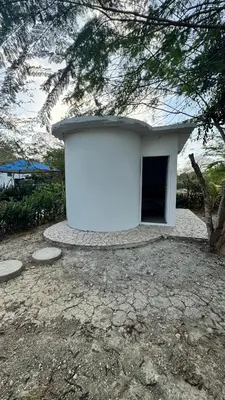 a white building with a door in a yard at Cabañas en Cartagena JhonliMar in Isla de Tierra Bomba