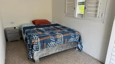 a bed in a room with a blue and white comforter at Cabañas en Cartagena JhonliMar in Isla de Tierra Bomba