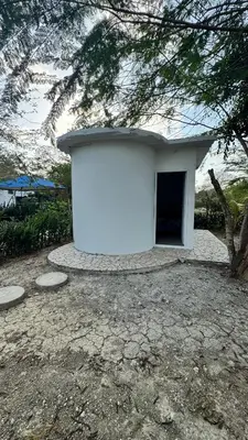 a white building with a door in a yard at Cabañas en Cartagena JhonliMar in Isla de Tierra Bomba