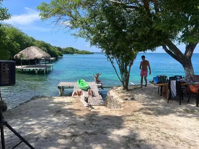 a man standing on a beach next to a body of water at Agua Zalada in Isla Grande