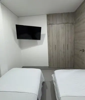 a bedroom with two beds and a flat screen tv at Espectacular Apartamento Amoblado - 2 Habitaciones in Barranquilla