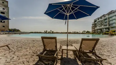 two chairs and an umbrella on a beach at Baia Kristal Cartagena in Cartagena de Indias