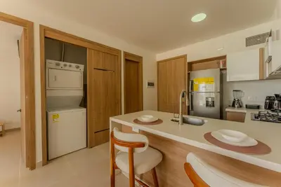 a kitchen with a sink and a counter with chairs at Baia Kristal Cartagena in Cartagena de Indias