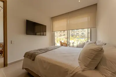 a bedroom with a large bed and a television at Baia Kristal Cartagena in Cartagena de Indias