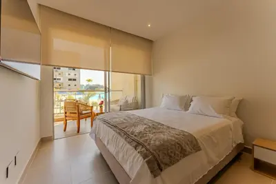 a bedroom with a large bed and a balcony at Baia Kristal Cartagena in Cartagena de Indias