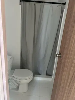 a bathroom with a toilet and a shower curtain at Cozy apartment in the heart of Barranquilla in Barranquilla