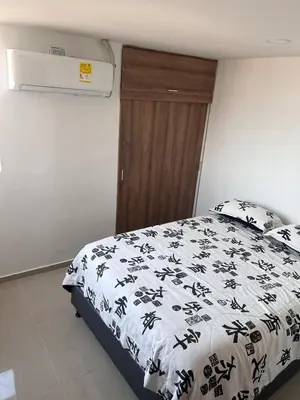 a bedroom with a bed with a black and white comforter at Cozy apartment in the heart of Barranquilla in Barranquilla