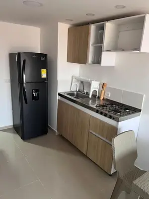 a kitchen with a black refrigerator and a sink at Cozy apartment in the heart of Barranquilla in Barranquilla