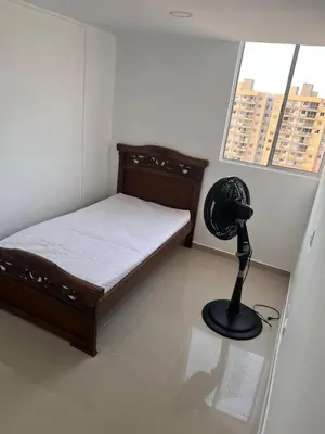 a small bedroom with a bed and a fan at Cozy apartment in the heart of Barranquilla in Barranquilla