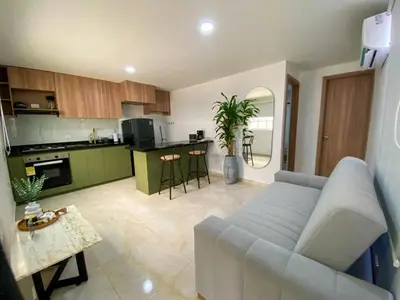 a living room with a couch and a kitchen at Apartamento Sabaii 201 in Cartagena de Indias