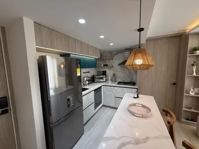 a kitchen with a stainless steel refrigerator and a table at Open Floor Chic Interior Design Pool Full Kitchen in Barranquilla
