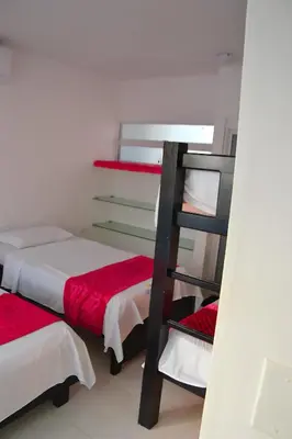 a bunk bed room with two beds and a ladder at Cabaña AveMaria in Coveñas