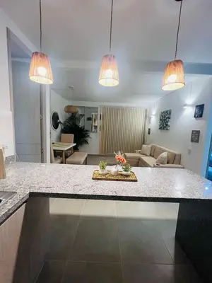 a kitchen with two pendant lights and a living room at Apartamento Descanso Cartagena in Manzanillo del Mar