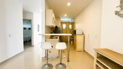 a kitchen with two white stools in a room at Magico Apartamento Frente al Mar 3 Habitaciones AR12 in Coveñas