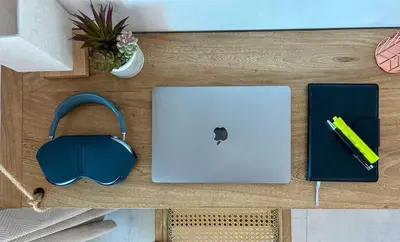 a desk with a laptop and headphones and a pen at Despierta en Tolú, un escenario de película in Tolú