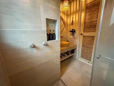 a bathroom with a shower with bottles of wine at Despierta en Tolú, un escenario de película in Tolú