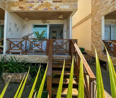 a house with a wooden staircase leading to the front porch at Despierta en Tolú, un escenario de película in Tolú