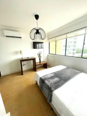a bedroom with a bed and a table and a chandelier at Cabrero Beach 1008 in Cartagena de Indias