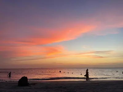 a group of people on the beach at sunset at sui lofts 1609 in Santa Marta