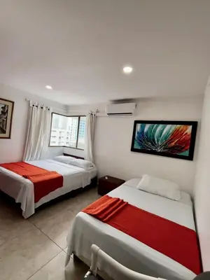 a bedroom with two beds and a tv on the wall at Apartamentos en Bocagrande frente al mar in Cartagena de Indias
