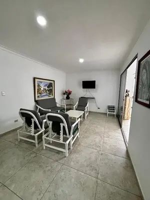 a living room with chairs and a table and a television at Apartamentos en Bocagrande frente al mar in Cartagena de Indias