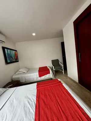 a bedroom with two beds with a red blanket on them at Apartamentos en Bocagrande frente al mar in Cartagena de Indias