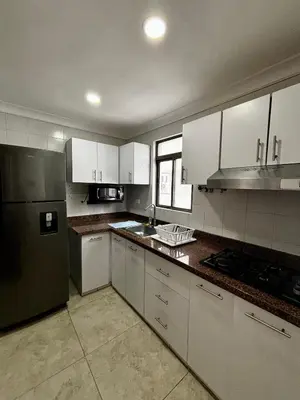 a kitchen with white cabinets and a stainless steel refrigerator at Apartamentos en Bocagrande frente al mar in Cartagena de Indias