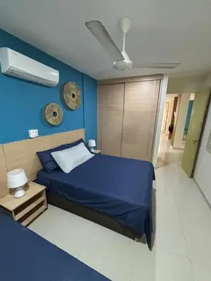 a bedroom with a bed and a blue wall at Refugio junto al mar en el Cabrero in Cartagena de Indias