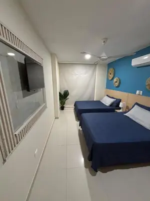 a room with two beds and a flat screen tv at Refugio junto al mar en el Cabrero in Cartagena de Indias
