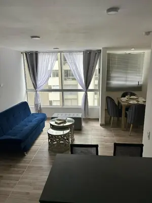 a living room with a blue couch and a table at Apartamento en Barranquilla in Puerto Colombia