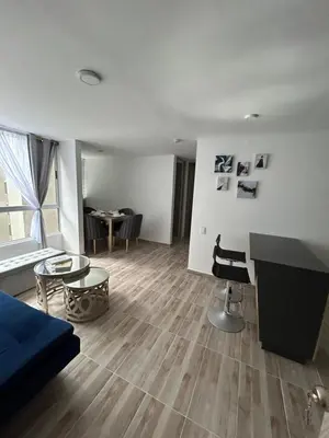 a living room with a blue couch and a table at Apartamento en Barranquilla in Puerto Colombia