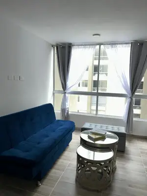 a living room with a blue couch and a table at Apartamento en Barranquilla in Puerto Colombia