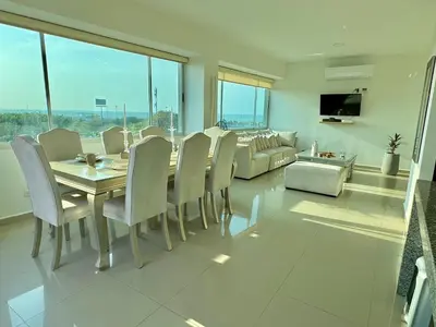 a dining room with a table and chairs and a couch at Luxury penthouse cerca al mar y centro historico in Cartagena de Indias