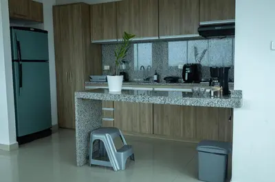 a kitchen with a counter with a stool and a refrigerator at Luxury penthouse cerca al mar y centro historico in Cartagena de Indias