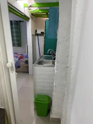 a kitchen with a sink and a green trash can at Apartaestudios Ofir in Barranquilla
