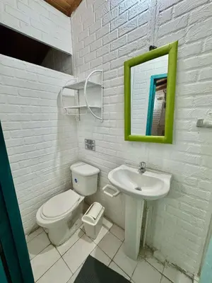 a white bathroom with a toilet and a sink at Apartaestudios Ofir in Barranquilla