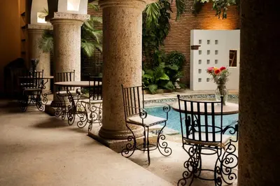 a patio with tables and chairs and a pool at Hotel Boutique Patio Corao in Cartagena de Indias