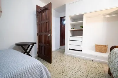 a bedroom with a bed and a wooden door at Casa Caribe, excellent location in Bocagrande in Cartagena de Indias