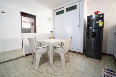a table and chairs and a refrigerator in a room at Casa Caribe, excellent location in Bocagrande in Cartagena de Indias