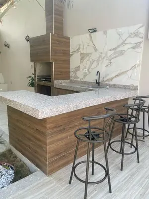 a kitchen with a counter with four bar stools at Luxury cabin in Santa Veronica in Santa Veronica