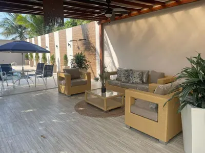 a patio with a couch and chairs and an umbrella at Luxury cabin in Santa Veronica in Santa Veronica
