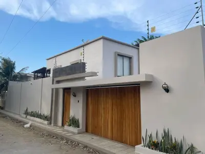 a white house with a wooden door at Luxury cabin in Santa Veronica in Santa Veronica