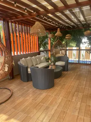 a patio with couches and chairs on a wooden floor at Luxury cabin in Santa Veronica in Santa Veronica